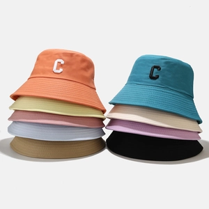 Bobs en coton avec logo C brodé en plusieurs couleurs vives sur fond blanc immaculé
