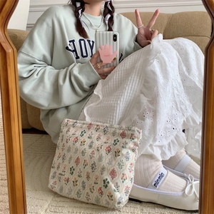 Close-up of floral cotton pouch held against casual outfit for lifestyle display