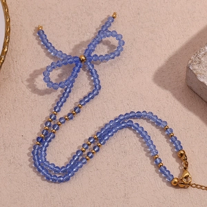 Detailed view of blue faceted crystal beads and gold metal beads tied in a bow shape