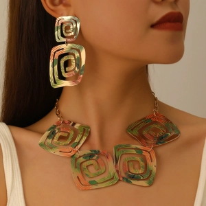 Parure de bijoux géométriques dorés avec motif de feuilles tropicales et boucles d'oreilles