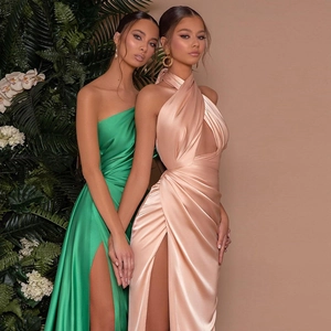 Detail of satin halter neck dress with sexy cutout and high slit in green and gold