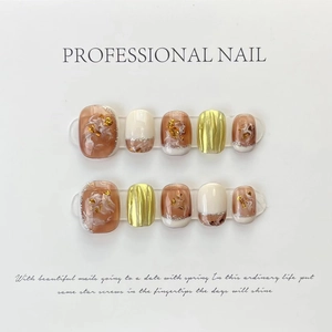 Detalle de uñas postizas hechas a mano con mármol ámbar, pan de oro y acabado metálico