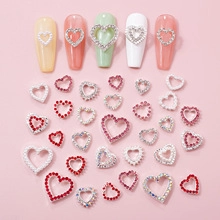 Detailed view of heart-shaped nail charms with rhinestones on colorful press-on nails