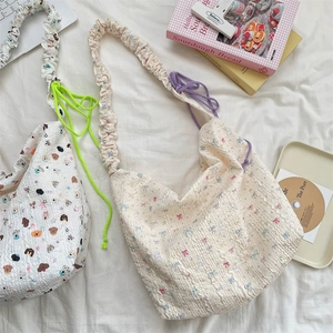 Détail de sacs à bandoulière en toile avec imprimé floral, animal et cordons colorés