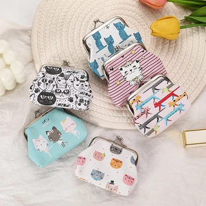 Assorted canvas coin purses with cute cat patterns and metal clasps on a woven mat