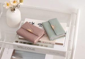 Close-up of pink and green PU leather wallets with quilted stitching and gold hardware