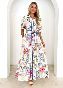 Detailansicht der Retro-Blumenmuster und des gestuften Maxirocks am weißen Hemdkleid