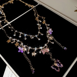 Close-up of sparkling crystal butterfly charms on luxury gold double layer necklace