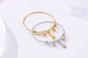 Detail of adjustable metal bead bracelets with guitar pendants in gold and silver finish