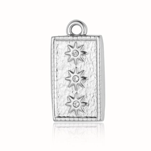 Macro detail of silver textured rectangular pendant with three sparkling star zircon stones