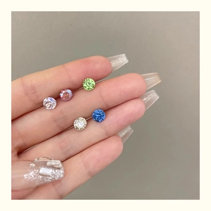 Close-up of colorful round crystal stud earrings held in hand with flat screw backs