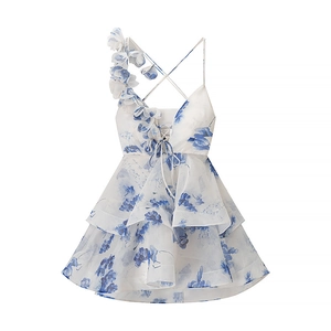 Detail van wit-blauwe bloemen organza jurk met 3D bloembandjes en gelaagde rucheszoom