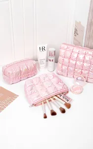 Three-piece set of pink holographic quilted makeup bags with shiny pearl finish storage