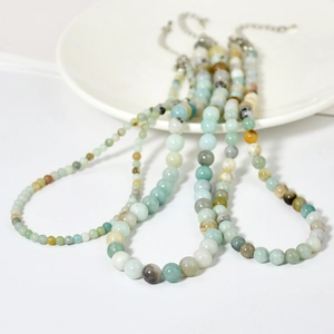 Détail macro d'un collier en perles d'amazonite et agate avec fermoir mousqueton argent
