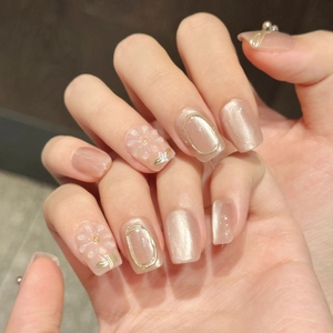 Handmade cat-eye press-on nails in nude pink and champagne gold with 3D floral accents