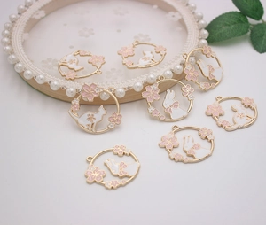 Close-up of alloy enamel charms featuring white rabbit and cat with pink cherry blossoms