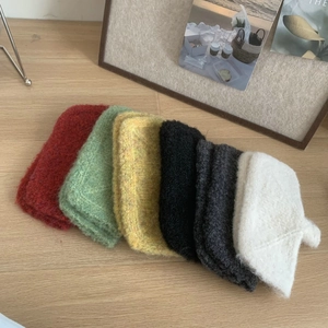 Flat lay of knit fingerless gloves in red, green, yellow, black, grey and white colors