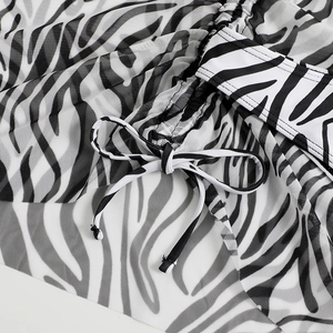 Detail of black and white zebra print mesh fabric with adjustable drawstring bow
