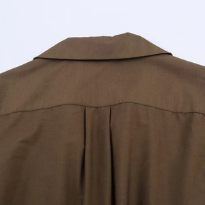 Detail of brown poplin shirt dress showing back yoke stitching and fabric texture