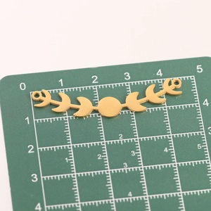 Detailed macro view of gold moon phase pendant measuring 4.5cm on a scale mat
