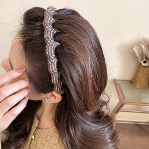 Close-up detail of wavy knitted acrylic headband in brown blend on female model