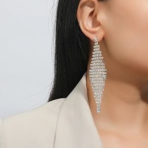 Close-up of sparkling silver tassel earrings with rhinestones worn by a model