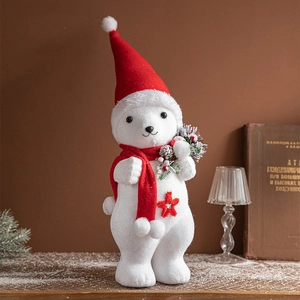 White foam Christmas bear with red hat and scarf on wooden table with festive decor