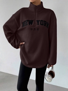 Détail de la broderie New York USA et texture polaire du sweat marron oversize