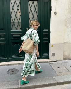 Detail view of floral print long maxi dress with puff sleeves and natural straw shoulder bag