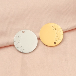 Close-up of gold and silver stainless steel star pendants on soft pink silk