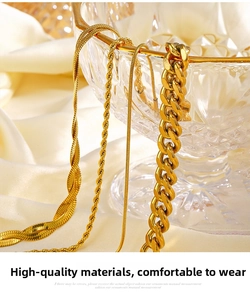 Detail of assorted golden stainless steel snake and twist chain necklaces on white silk