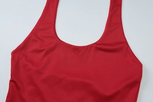 Detail of red knitted halter top showing deep U-neckline and fine fabric texture