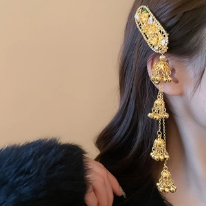 Close-up of golden ethnic hair clip with flowing tassel chains and small bell charms