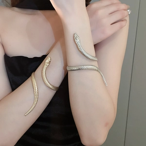 Close-up of gold and silver snake bracelets with detailed scale textures on wrist