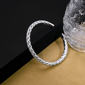 Detail of silver woven texture and knot design on minimalist adjustable open bangle