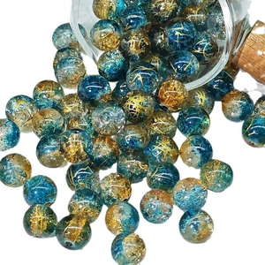 Blue and gold crackle glass beads 10mm spilling from a small glass bottle on white background