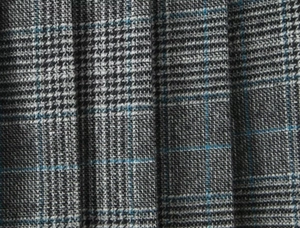 Vista macro della trama del tessuto scozzese grigio con accenti blu e pieghe nitide