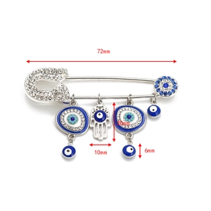 Detail view of Evil Eye and Hamsa Hand safety pin brooch with silver plating and rhinestones