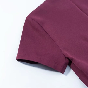 Détail de la manche courte d'une robe bouffante rouge vin avec couture de qualité