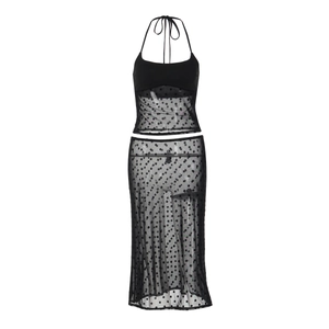 Détail du tissu en maille à pois noirs sur le haut licou et la jupe midi assortie