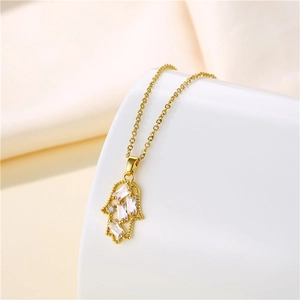 Nahaufnahme des goldenen Hamsa-Hand-Anhängers mit Zirkonia auf weißem Sockel