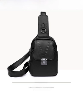 Détail du sac de poitrine en cuir noir avec rivets en V et boucle métallique robuste