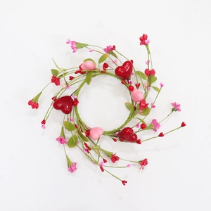 Close-up of Valentine candle ring with red pink hearts and floral berry details