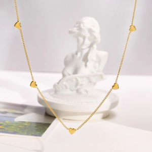 Elegant 18K gold plated necklace with small heart charms displayed against a white background