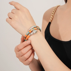 Close-up of a multi-colored snake-shaped bracelet with orange and turquoise segments