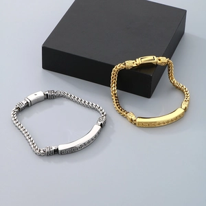 Detail of gold and silver men's dragon bone link bracelets with Greek fret patterns
