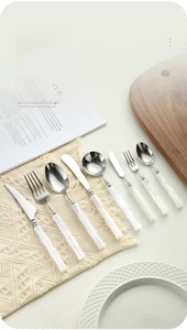 Detail of 304 stainless steel cutlery with white bamboo-shaped acrylic handle on a plate