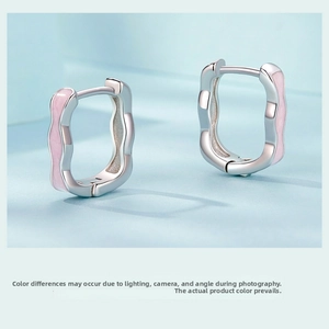 Macro view of wave-textured S925 sterling silver earrings with pink enamel details