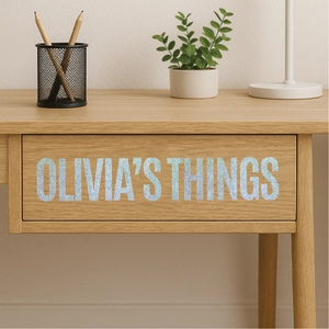 Close-up of glitter holographic letter stickers on a wooden drawer for personalization