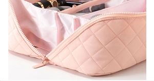Detailed macro view of pink quilted makeup bag showing internal compartments and soft fabric
